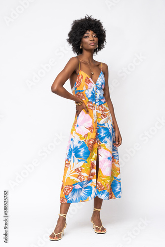 Fashionable African woman with curly hairs and floral dress on isolated white background.