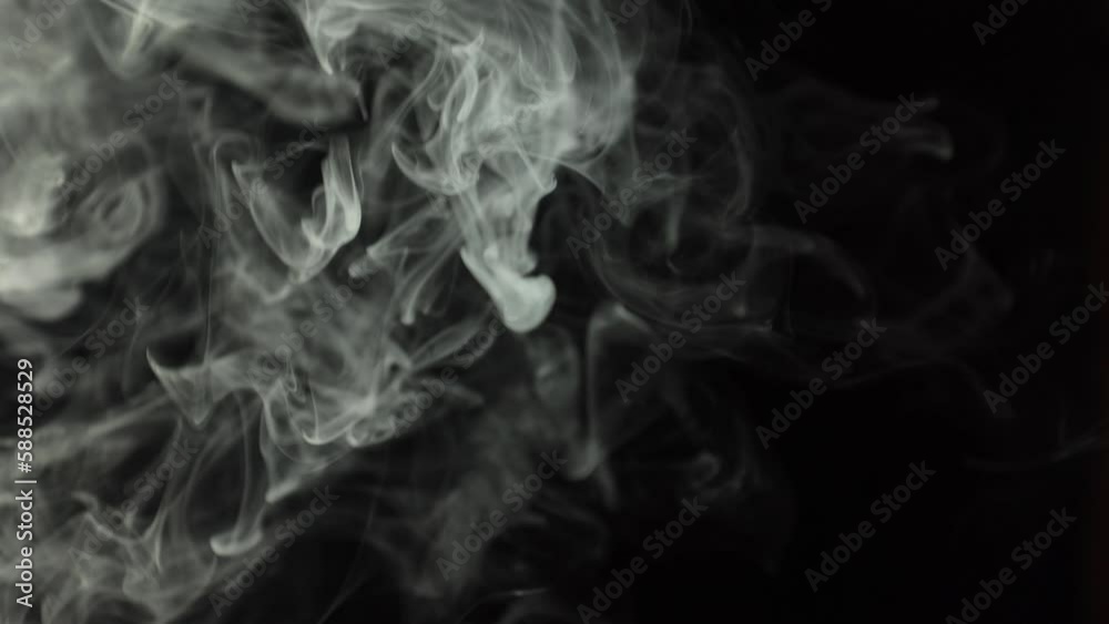 Black background and smoke. Lots of cigarette smoke. Suitable for effects in various videos. It's a pity for the environment. Stop smoking in public places. Thick white smoke on a black background.