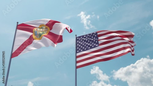 Florida and the USA on a flagpole realistic wave on strong wind in blue sky. State of Florida and The United States of America