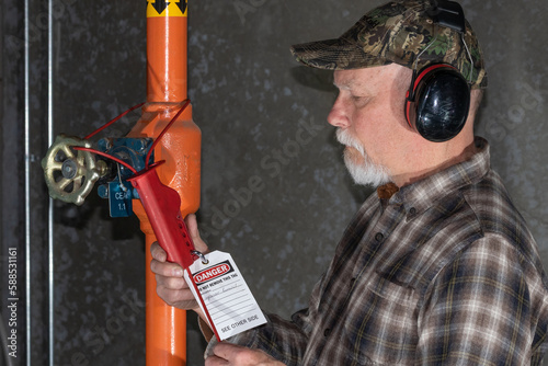 man applying lockout tagout on ammonia valve photo
