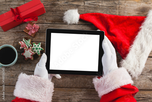 Santa claus holding digital tablet on wooden plank