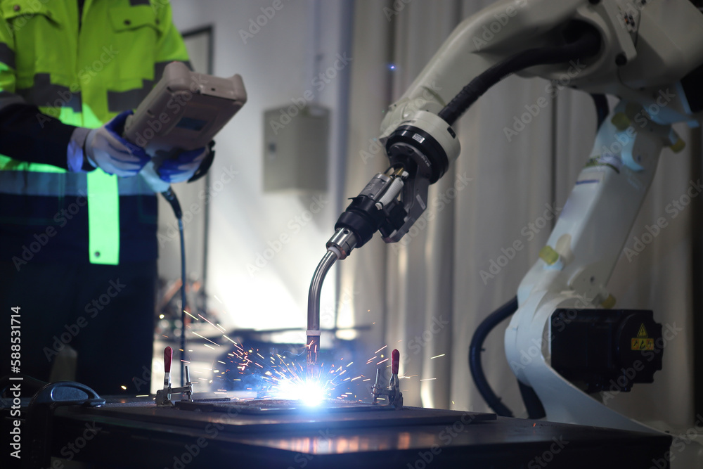 engineer teaching robot welding machine , explanation how to working of robot arm , all function