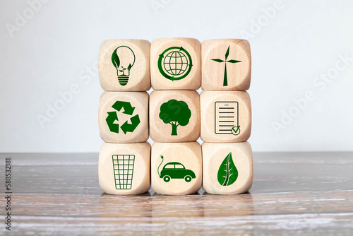 Green and eco building concept. wooden cubes with green building symbols on the natural background. photo