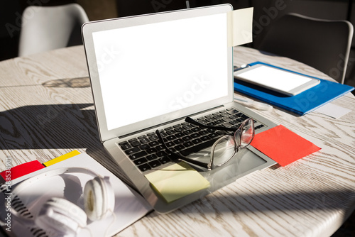 Laptop and eyeglasses on table