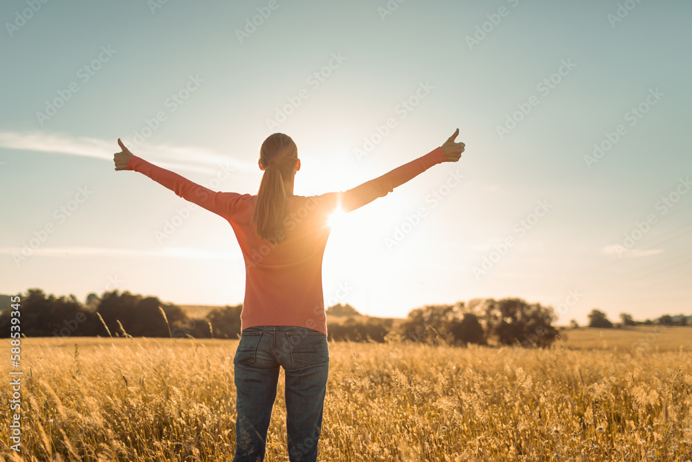 Young female feeling grateful, joyful standing outdoors in the sunrise Young female feeling grateful, joyful standing outdoors in the sunrise