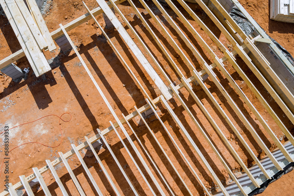 Installation work wood floor joist trusses layout on concrete block foundation new custom home Installation work wood floor joist trusses layout on concrete block foundation new custom home