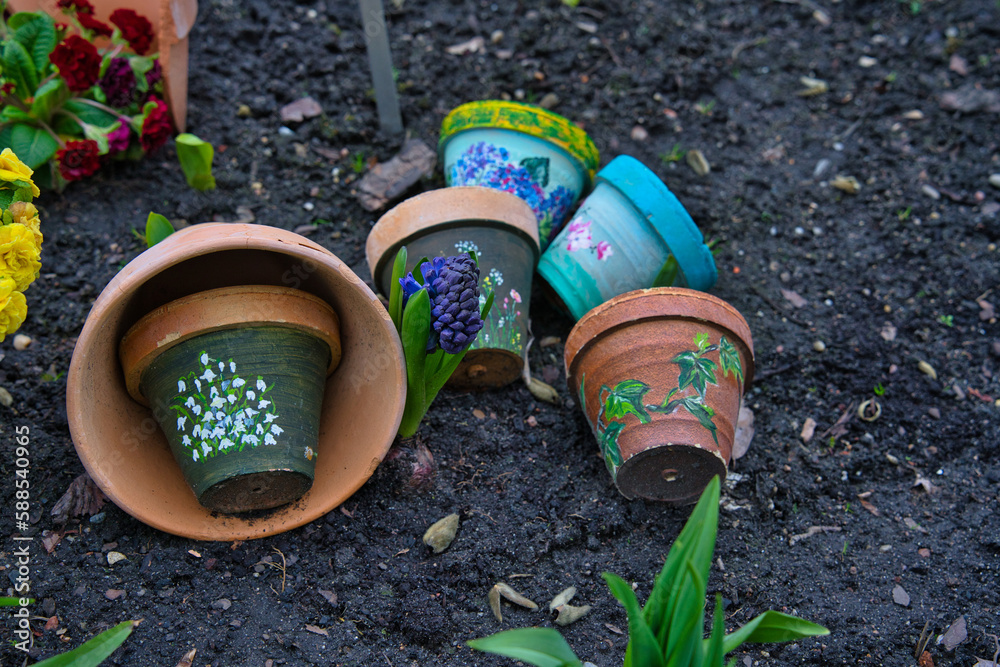 colorful pots painted in spring patterns with flowers in the garden colorful pots painted in spring patterns with flowers in the garden