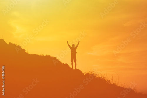 Hiker with arms up standing on the top of the mountain - Successful man enjoying triumph - Sport and success concept 
