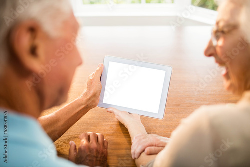 Rear view of senior couple using digital tablet