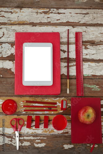 School supplies with digital tablet and apple on wooden table