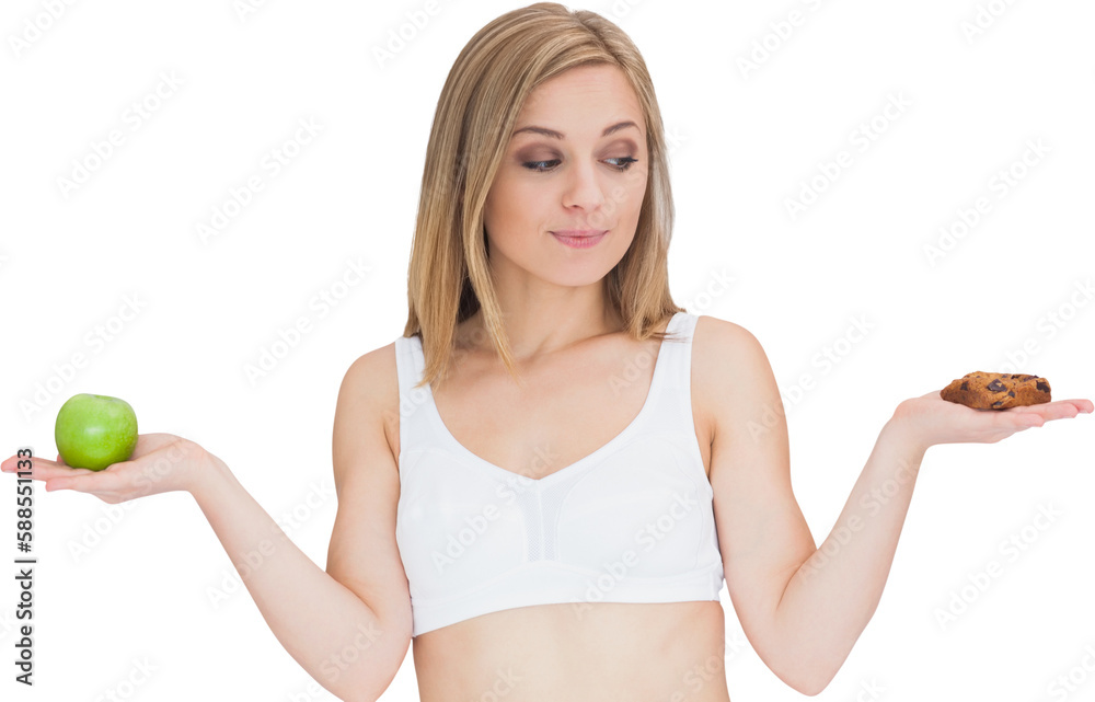 Young woman with apple looking at cookie Young woman with apple looking at cookie