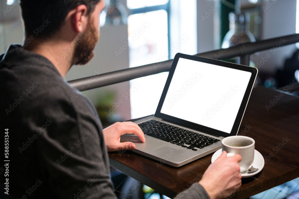 Man holding coffee cup and using laptop Man holding coffee cup and using laptop