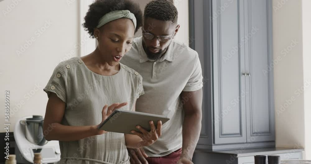 Happy african american couple using tablet in ktichen in slow motion Happy african american couple using tablet in ktichen in slow motion