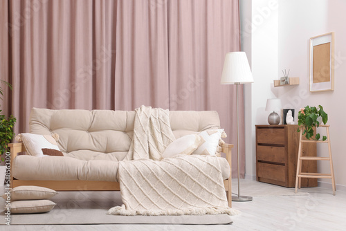 Comfortable sofa  cushions and blanket in cozy room. Interior design