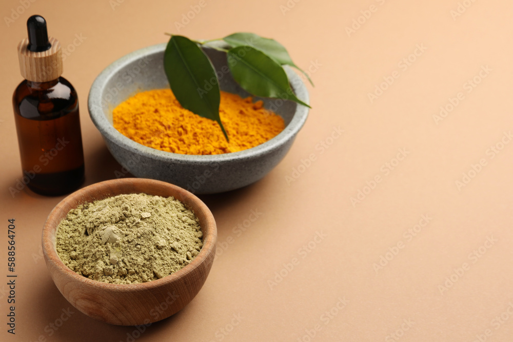 Bottle, henna and turmeric powder on coral background, space for text. Natural hair coloring Bottle, henna and turmeric powder on coral background, space for text. Natural hair coloring