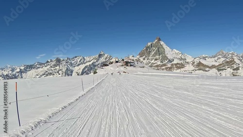 POV of a skier in Zermatt. Skier is skiing on straight track ski slope and in front of him is Matterhorn. He is in Plateau Rosa, Testa Grigia region in Zermatt photo
