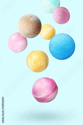 Many different bath bombs falling on pastel light blue background