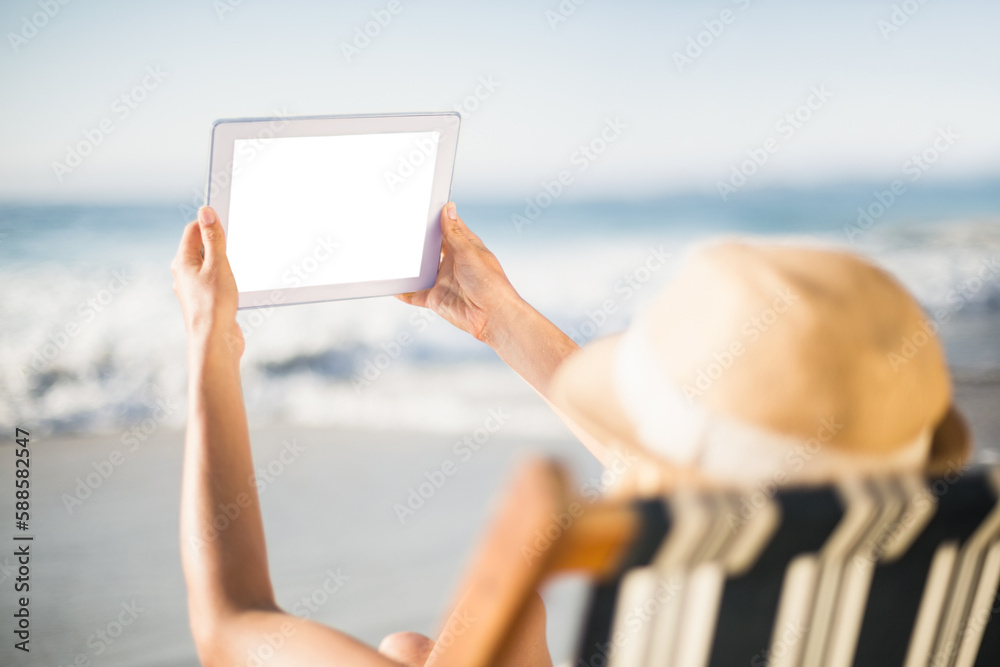 Woman using digital tablet on beach