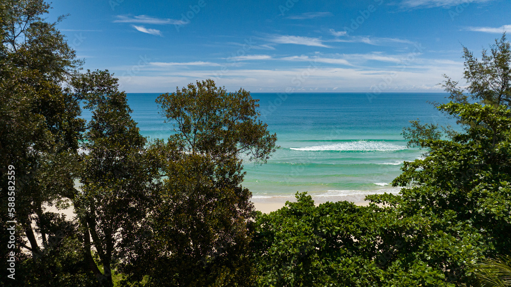Tropical beach and blue sea through the trees. Sabah, Borneo, Malaysia.