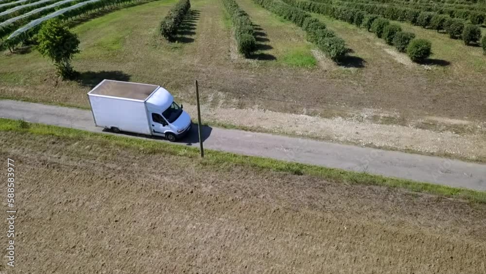 White Delivery Truck driving country road filmed by drone