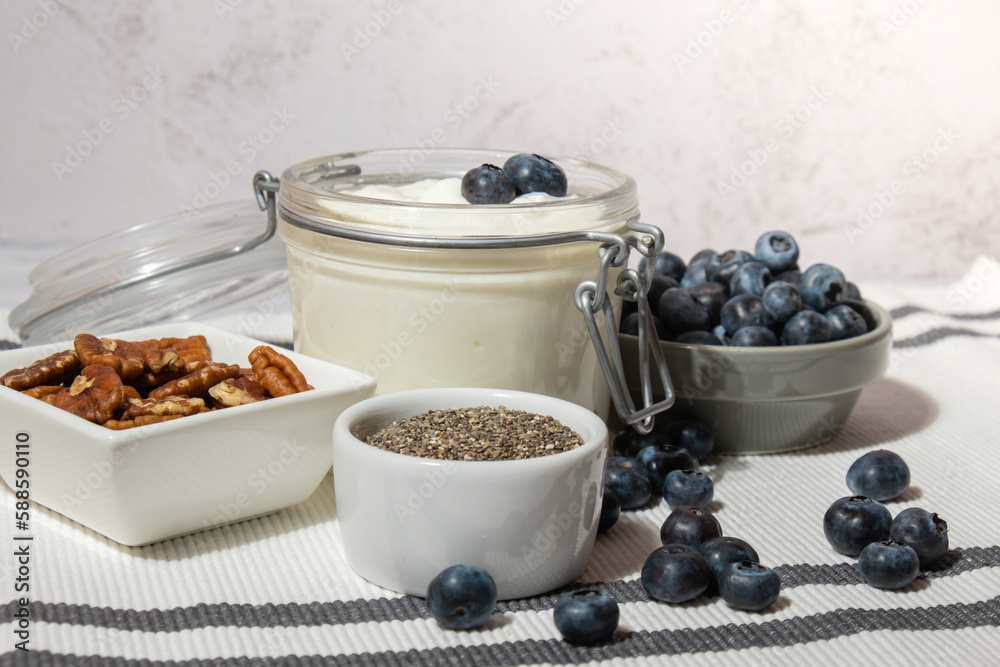 Glass jar with natural organic homemade yogurt and blueberries pecan