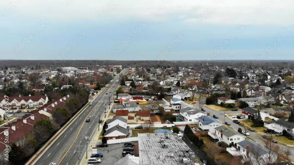 Elevating Aerial Shot of a Residential Neighborhood with a Wide Road Stretching Along the Houses under a Cloudy Sky, Long Island, New York, USA (UHD) Elevating Aerial Shot of a Residential Neighborhood with a Wide Road Stretching Along the Houses under a Cloudy Sky, Long Island, New York, USA (UHD)