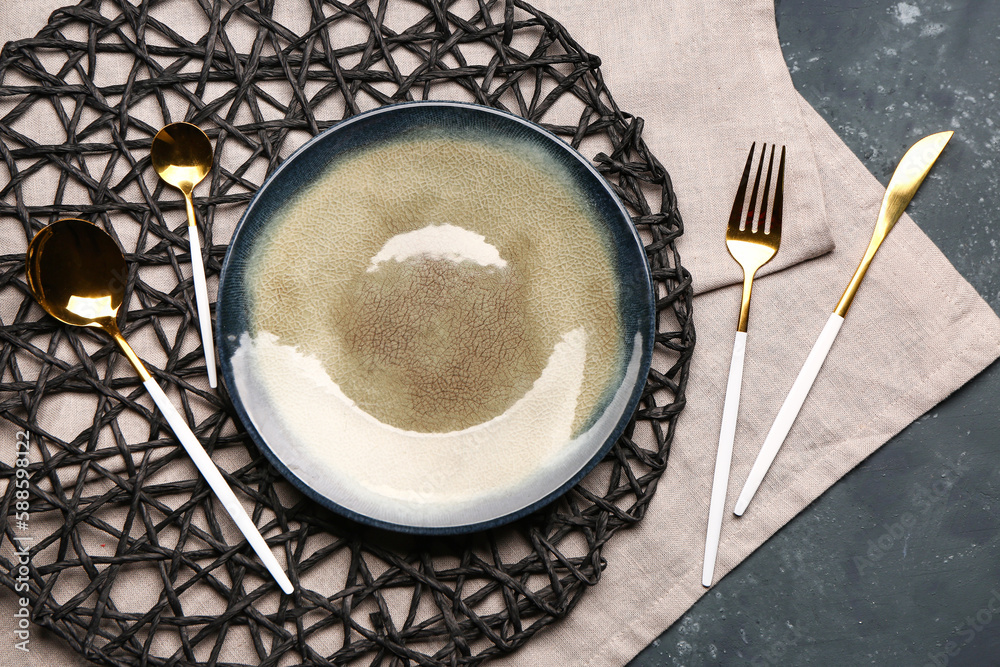 Tablecloth with plate and set of cutlery on grey grunge background Tablecloth with plate and set of cutlery on grey grunge background