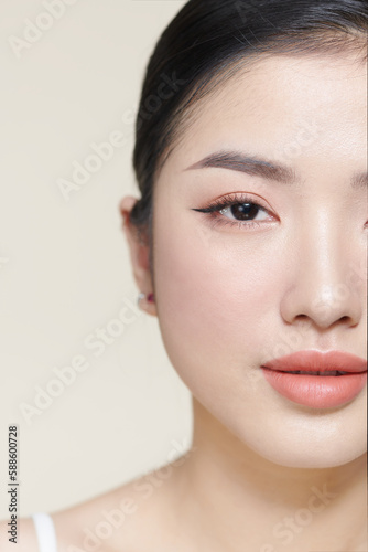 Beautiful young Asian woman with clean fresh skin on brown background