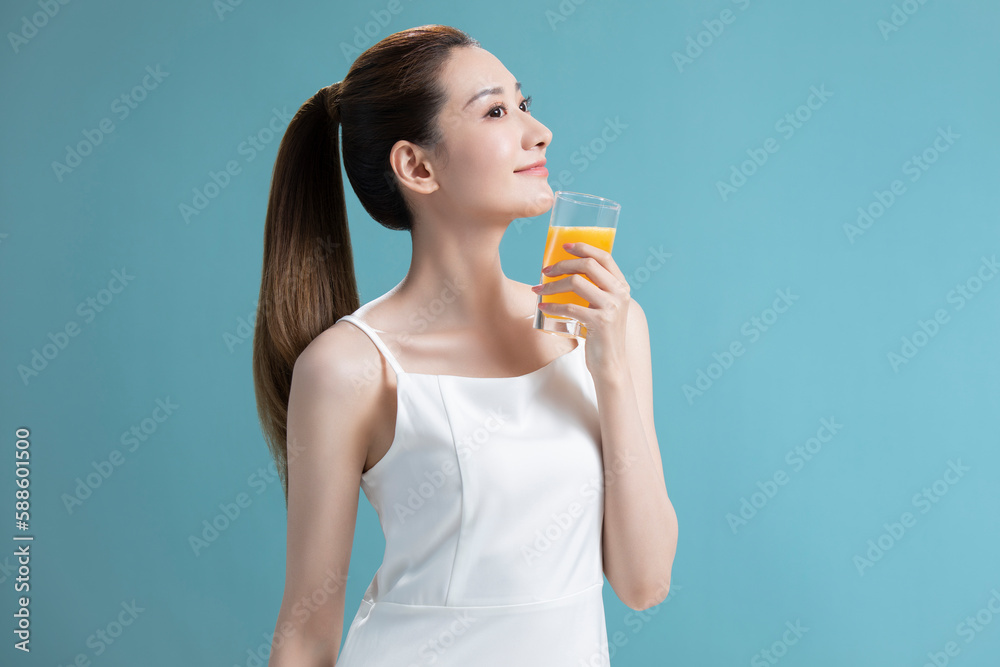 Beautiful young Chinese woman drinking orange juice Beautiful young Chinese woman drinking orange juice