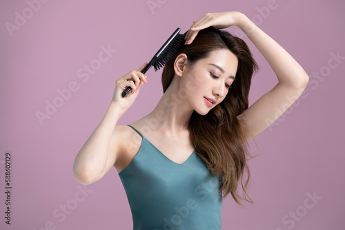 Beautiful young Chinese woman combing long hair photo