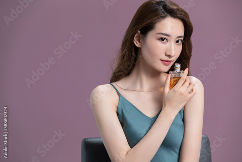 Beautiful young Chinese woman with perfume photo