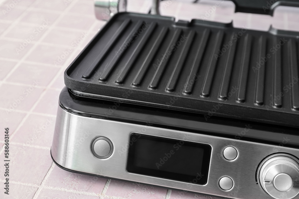 Obraz premium Control panel of modern electric grill on pink tile table, closeup