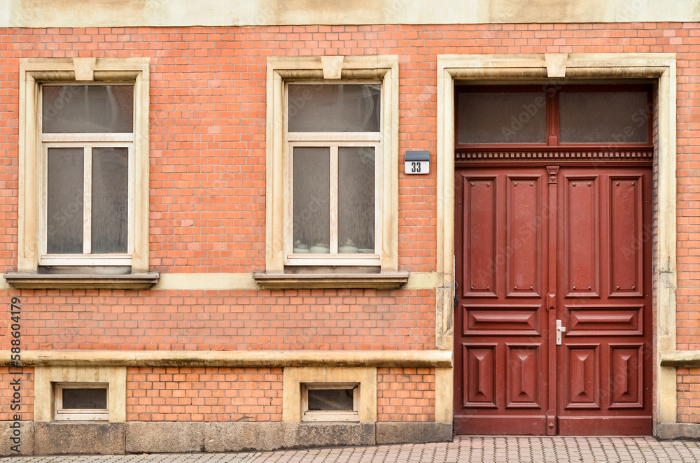 View of brick building with wooden door and windows