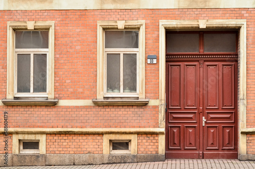 View of brick building with wooden door and windows © Pixel-Shot