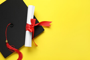 Diploma with red ribbon and graduation hat on yellow background