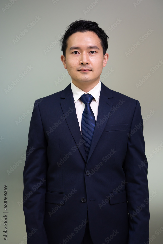 Portrait Asian business man standing look at camera in modern office. Portrait Asian business man standing look at camera in modern office.