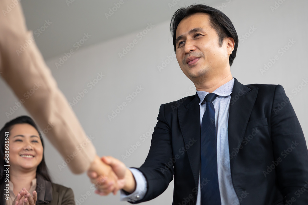 Asian business man shaking hands on a business cooperation agreement. Successful businessmen handshaking after good deal