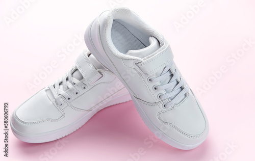 White sneakers on a pink background.