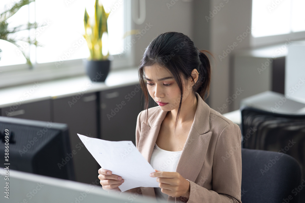 young asian business woman working on desk with desktop computer in modern home office. young asian business woman working on desk with desktop computer in modern home office.