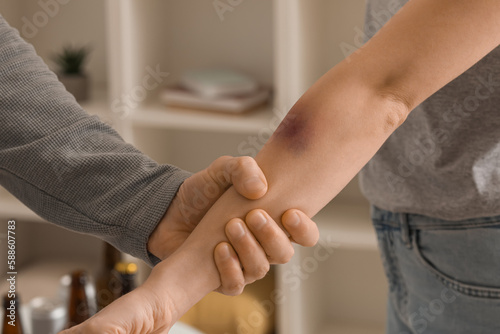 Young man hurting his wife at home, closeup. Domestic violence concept