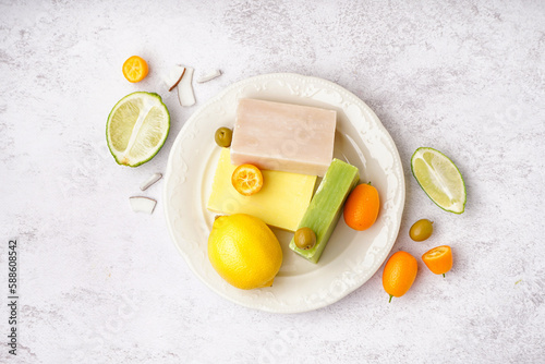Fototapeta Naklejka Na Ścianę i Meble -  Plate with natural soap bars fruits and olives on light background