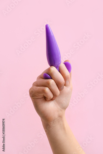 Woman with anal plug on pink background