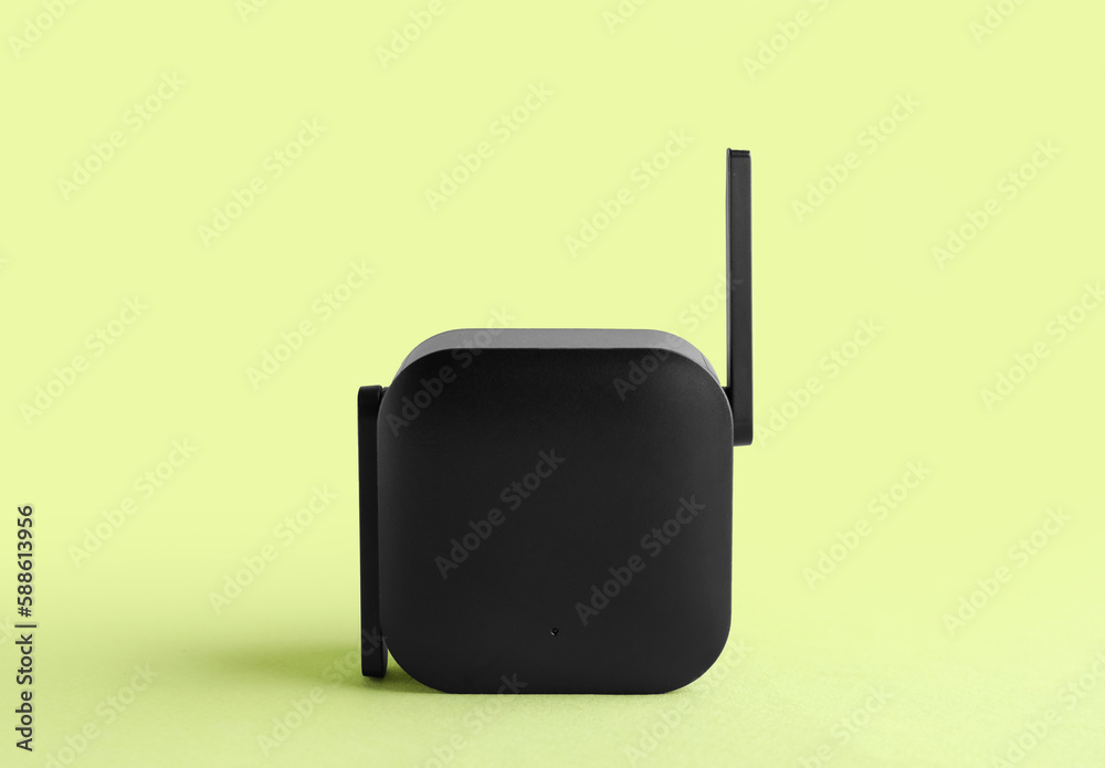 Black WiFi repeater on green background