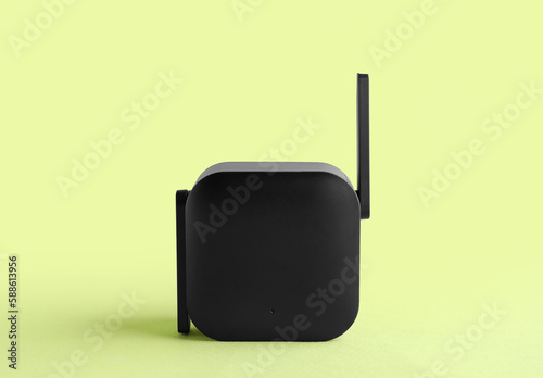 Black WiFi repeater on green background