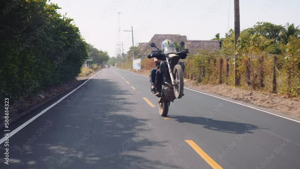 couple on dirt bike do a wheelie and chase camera at speed couple on dirt bike do a wheelie and chase camera at speed