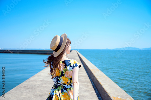 港の防波堤を歩く海のリゾートへ旅する女性 photo