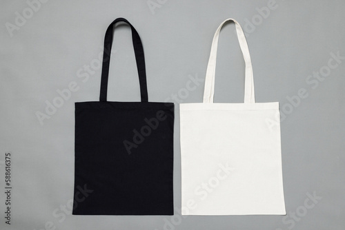 High angle view of black and white canvas bags with copy space on grey background