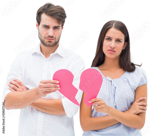 Upset couple holding two halves of broken heart
