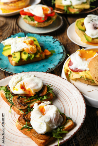 Plates with tasty eggs Benedict on wooden background