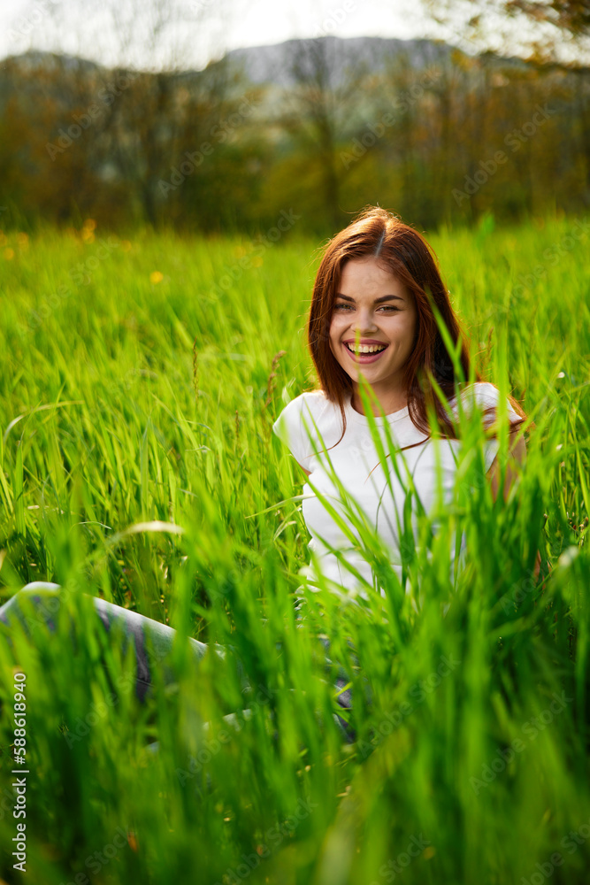 portrait of a laughing red-haired woman sitting in the grass portrait of a laughing red-haired woman sitting in the grass